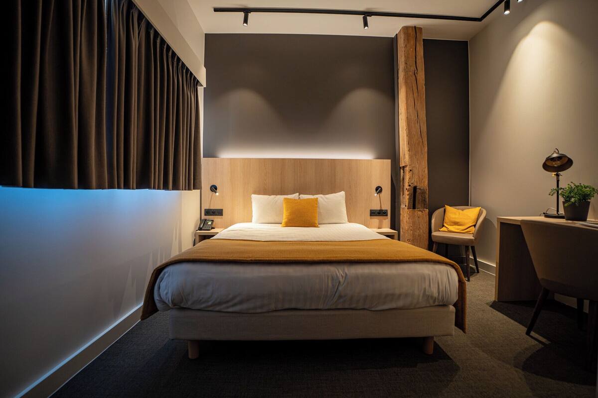 Ein modernes Hotelzimmer mit einem großen Bett, einem Schreibtisch und einem Sessel.