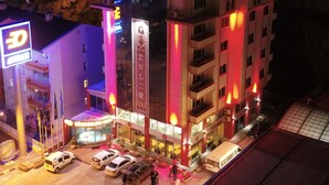 Un hotel de varios pisos con un letrero llamativo que dice 'MENLER HOTEL'.