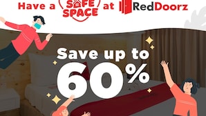 Un dormitorio con una cama, una mesita de noche y una manta roja.