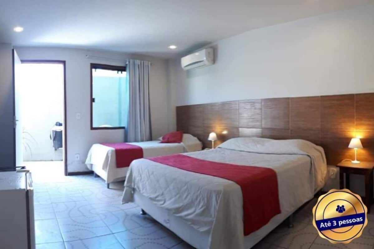 Ett hotellrum med två sängar, ett skrivbord och ett fönster.