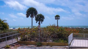 A coastal walkway with a no parking sign, palm trees, and a view of the ocean. - Beach View, Private Plunge Pool, Charming 1938 Bungalow Madeira Beach Gulf-Blvd (Madeira Beach)