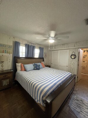 A bedroom with a bed, a ceiling fan, a window with curtains, and a door. - Beach View, Private Plunge Pool, Charming 1938 Bungalow Madeira Beach Gulf-Blvd (Madeira Beach)