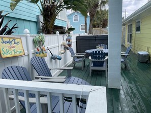 A covered outdoor patio with Adirondack chairs, a table, and a sign reading "Sandy Toes and Salty Kisses." - Beach View, Private Plunge Pool, Charming 1938 Bungalow Madeira Beach Gulf-Blvd (Madeira Beach)