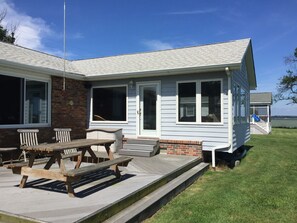 Une maison à deux étages avec un porche, un patio couvert et une petite terrasse.