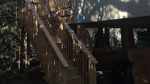 Une cabane en bois à deux étages, avec un escalier en bois menant à l’étage supérieur.