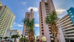 A tall, modern building with a prominent sign reading "PALMS." - 3BR Direct Oceanfront Condo in the Palms (Myrtle Beach)