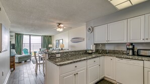 A kitchen with white cabinets, a granite countertop, and a dishwasher. - 3BR Direct Oceanfront Condo in the Palms (Myrtle Beach)