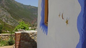 Un edificio rustico con un muro in pietra e una finestra.