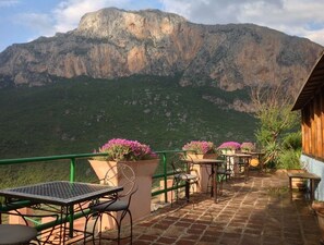 A terrace with tables and chairs, overlooking a mountainous landscape. - Caiat Refuge (Al Oued)
