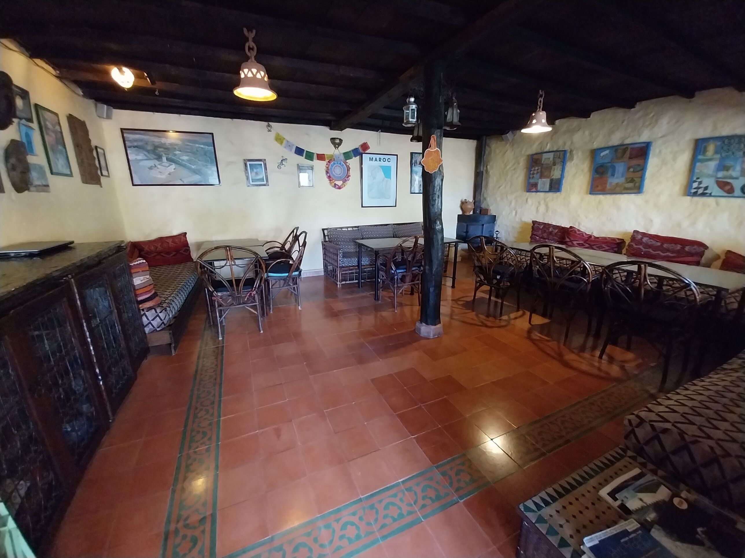 Un comedor acogedor con mobiliario de madera, piso de baldosas y una pared decorada con cuadros y un banderín.