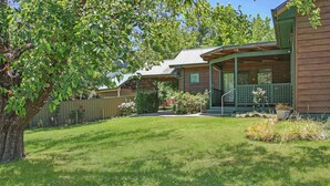 A two-story house with a covered porch, a fenced yard, and a well-maintained lawn. - River's Reach - Bright (Bright)