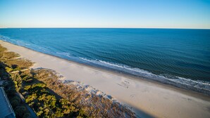 A beach with a clear view of the ocean and a path leading to the water. - $150 activities - E-gift card when you book - Contemporary Oceanfront Luxury | M2003 (Myrtle Beach)