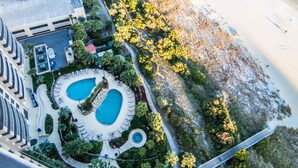 An aerial view of a resort with two swimming pools, a bridge, and a beach area. - $150 activities - E-gift card when you book - Contemporary Oceanfront Luxury | M2003 (Myrtle Beach)