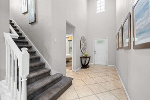 A staircase leading to a bedroom with a bed, a door, and a wall-mounted decorative item. - No Rear Neighbors • Pool & Spa • Game Room • Lazy River • Gated Resort 2167 (Kissimmee)