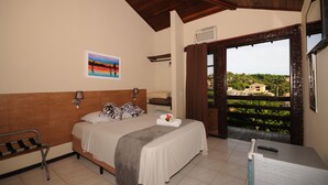 Habitación de hotel con cama, un banco, un cuadro y vistas al exterior.