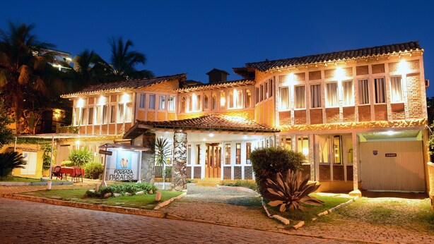 Un hotel con tejado de tejas, varias ventanas y una entrada bien iluminada.