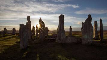 A landscape with standing stones under a clear sky.