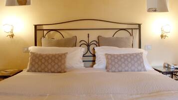 Una cama bien hecha con almohadas estampadas y un cabecero de metal.