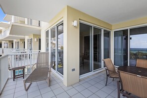 A balcony with a chair, a table, and a view of the sea. - Enjoy Private Pools, Gulf Front Property and Spectacular Views at Crescent 312. (Destin)
