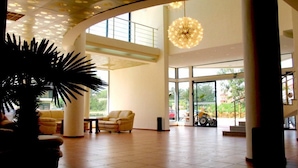 A spacious lobby with a high ceiling, large windows, and a central chandelier. - Hotel Shipka Beach (Sunny Beach)