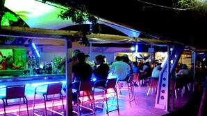 An outdoor bar area with metal chairs and tables, a counter with bottles, and a canopy overhead. - Hotel Shipka Beach (Sunny Beach)