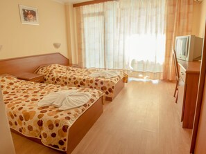 A hotel room with two beds, a TV, and a wooden cabinet. - Hotel Shipka Beach (Sunny Beach)