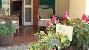 Un espace jardin privé aménagé avec des meubles en osier et un panneau indiquant qu’il est réservé à un usage privé.