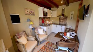 A cozy living room with a sofa, chairs, a coffee table, a patterned rug, and a television. - Casa Rosalba - WelcHome (Cannobio)