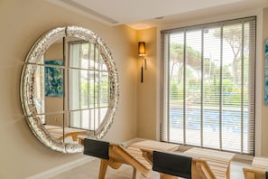 Una habitación con un espejo grande, muebles de madera y vistas amplias por las ventanas.