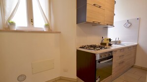 Eine kleine Küche mit Gasherd, Backofen und Holzschränken.