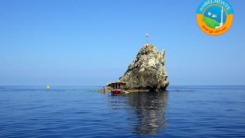 Experience the serene beauty of a natural rock formation surrounded by calm waters, perfect for relaxation or exploration.