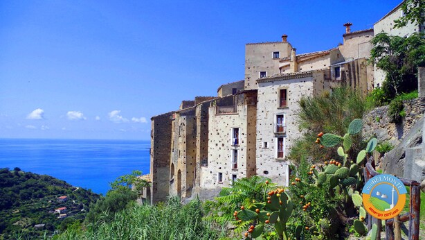 Un edificio costero con múltiples ventanas y balcones, con vista al mar.