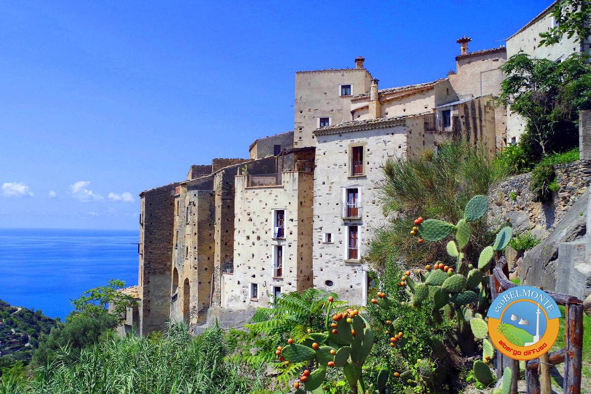 A coastal building with multiple windows and balconies, overlooking the sea.
