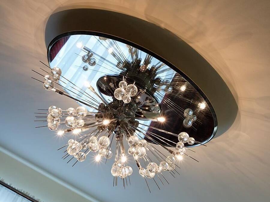 Ein moderner Kronleuchter mit mehreren Glühbirnen und metallischen Elementen.
