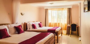 Habitación de hotel con dos camas, un escritorio y una silla.