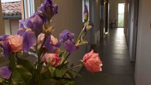 A hallway with a vase of purple and pink flowers on a wooden table. - B&B Cascina Belmonte (Fossano)