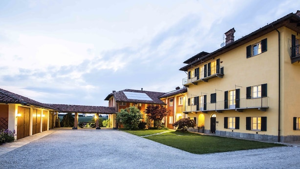 A two-story building with a gravel driveway and a well-maintained lawn. - B&B Cascina Belmonte (Fossano)