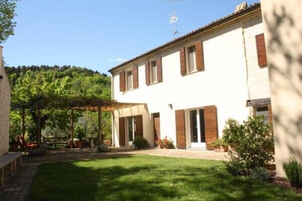 A two-story building with a covered patio area and a well-maintained lawn. - Agriturismo La Barca nel Bosco (Fano)