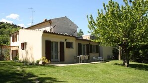 A two-story house with a patio area, a small garden, and a tree. - Agriturismo La Barca nel Bosco (Fano)