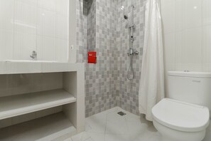 A bathroom with a shower, toilet, and sink.