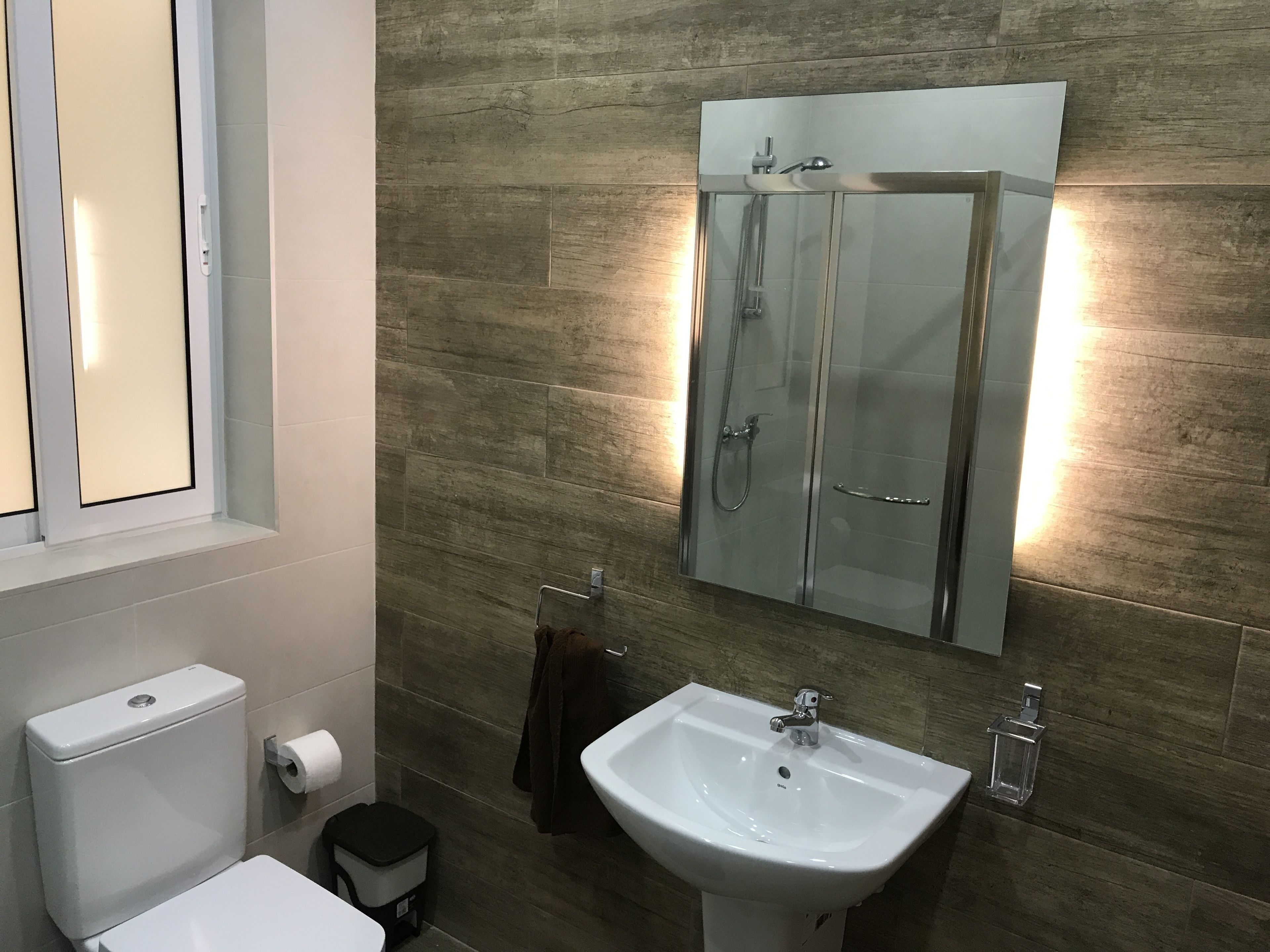 A modern bathroom with a toilet, sink, and a glass-enclosed shower.