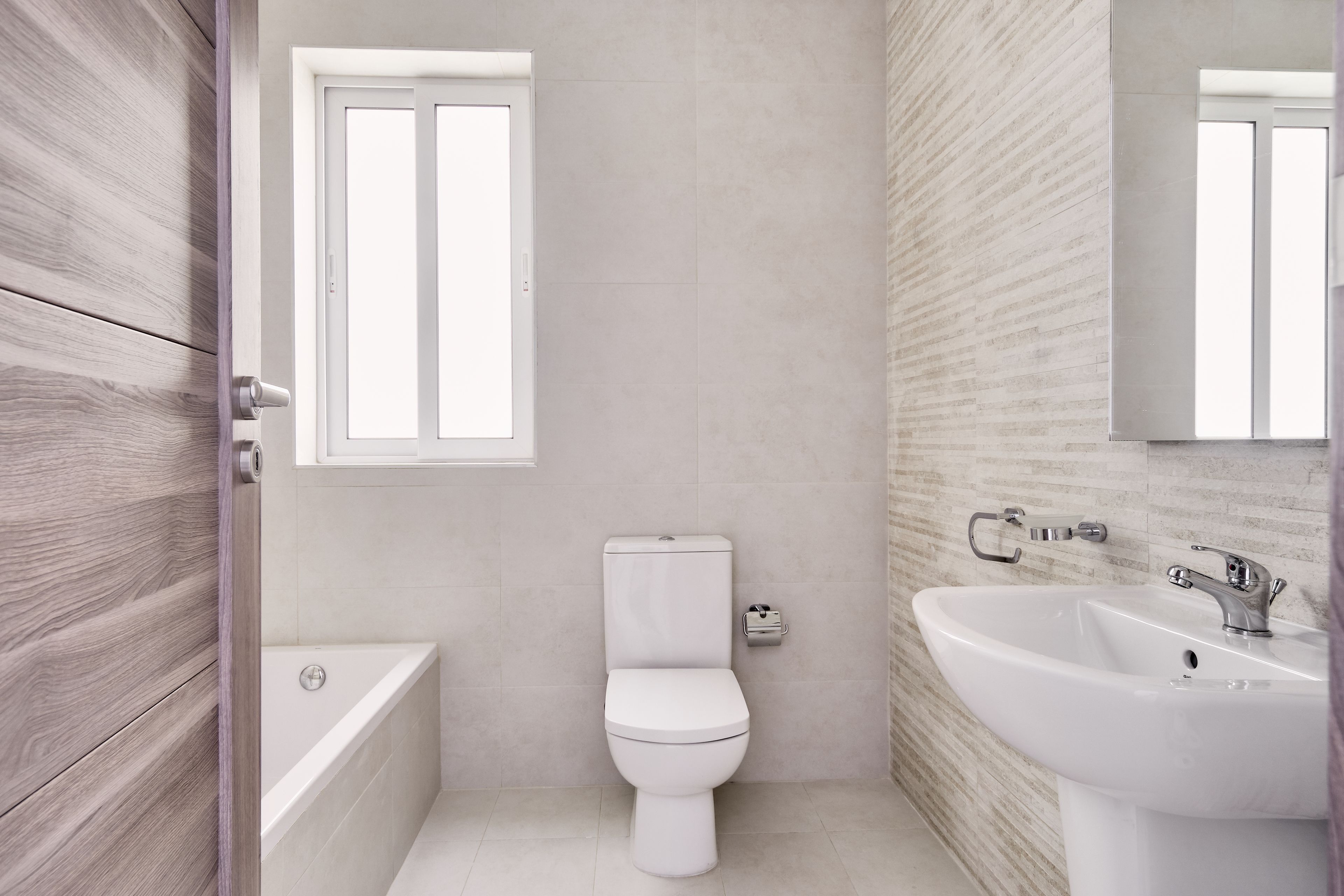 Une salle de bain moderne équipée de toilettes, d’une baignoire et d’un lavabo.