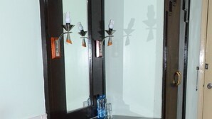 Una habitación con una mesa de madera oscura, un banco, un espejo y una puerta.