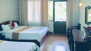 Ein Hotelzimmer mit zwei Betten, einem Esstisch und Blick ins Freie.