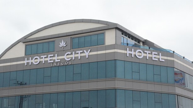 Een modern hotelgebouw met de naam 'HOTEL CITY' duidelijk zichtbaar op de gevel.