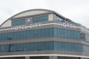 Ein modernes Hotelgebäude, auf dessen Fassade der Schriftzug "HOTEL CITY" gut sichtbar angebracht ist.