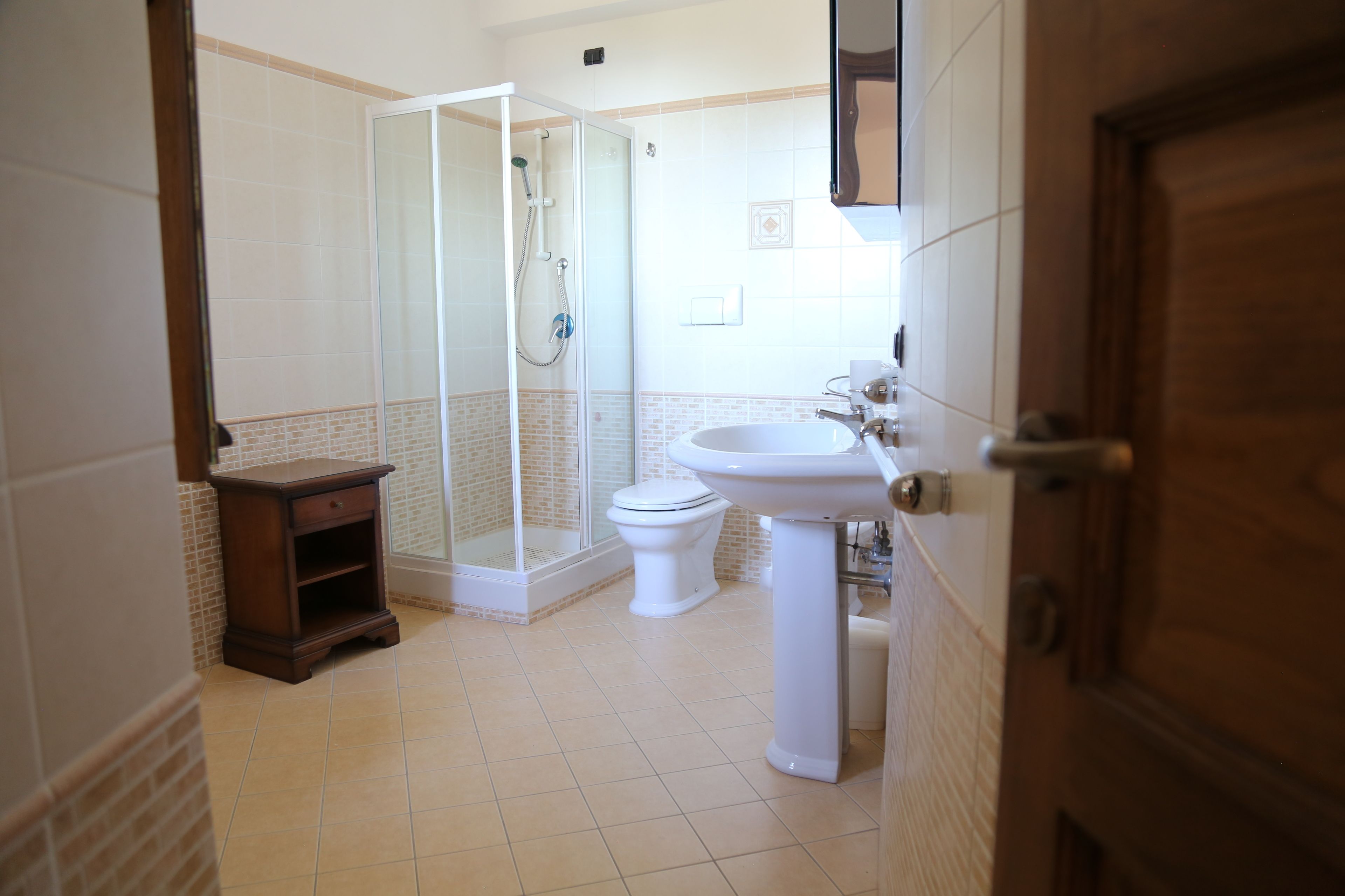 Ein Badezimmer mit Duschkabine, Toilette und Waschbecken.