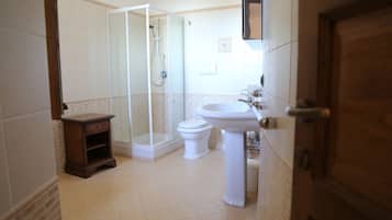 Ein Badezimmer mit Duschkabine, Toilette und Waschbecken.