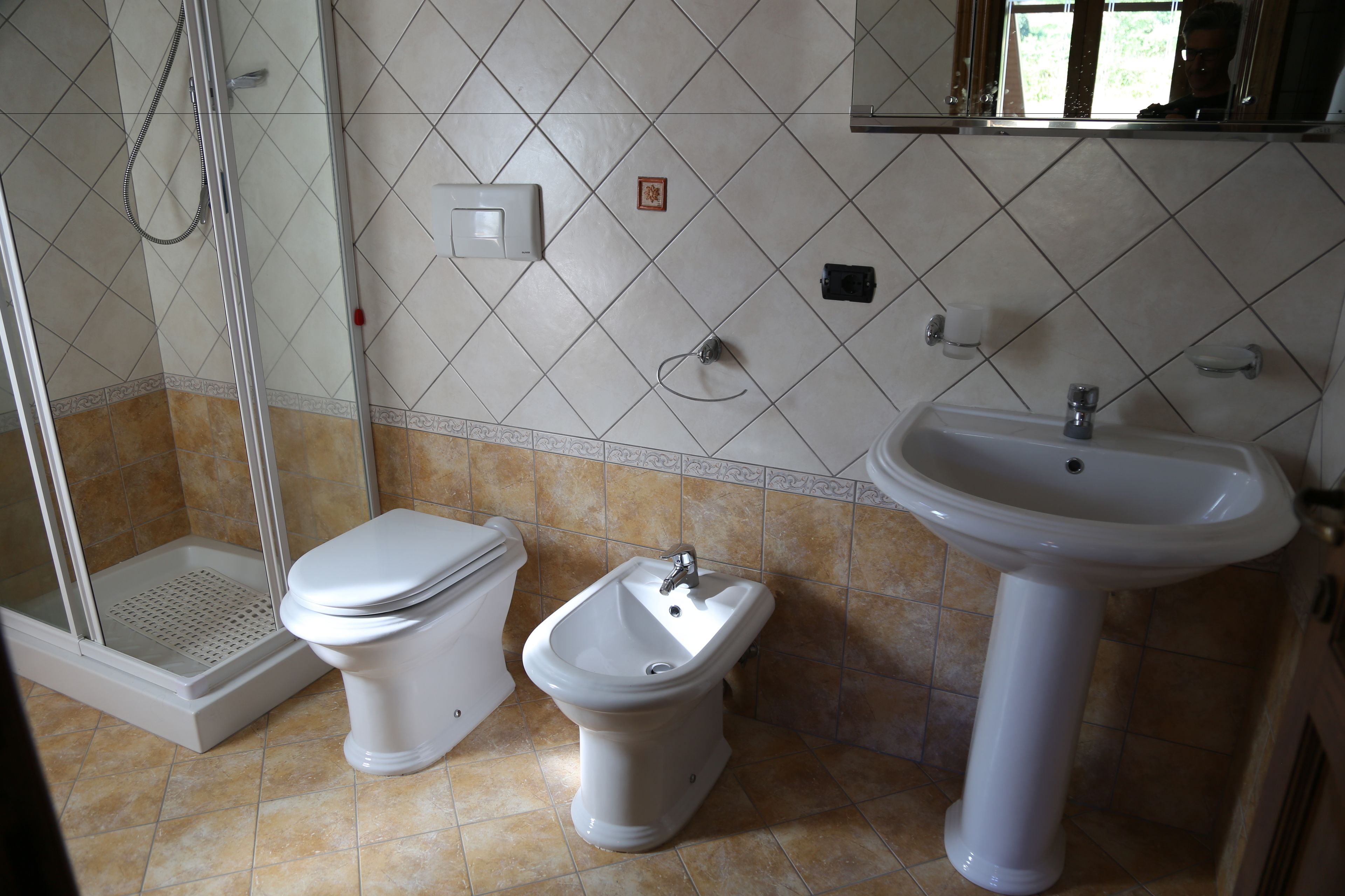 Une salle de bain équipée de toilettes, d’un bidet et d’un lavabo.