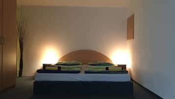 Une chambre à coucher avec un lit, deux lampes de chevet, une tête de lit en bois et un luminaire fixé au mur.